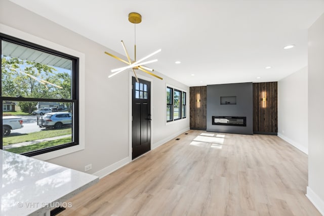 unfurnished living room featuring light hardwood / wood-style floors and a chandelier