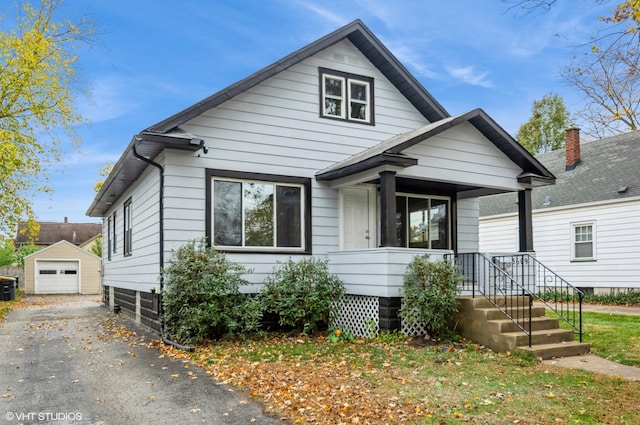 bungalow-style house with a garage and an outbuilding