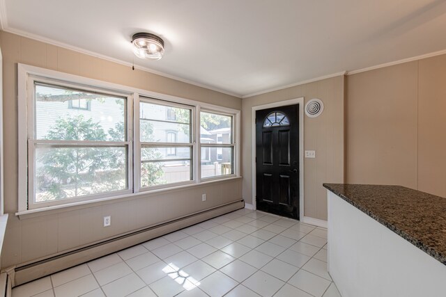 tiled entryway with baseboard heating and crown molding