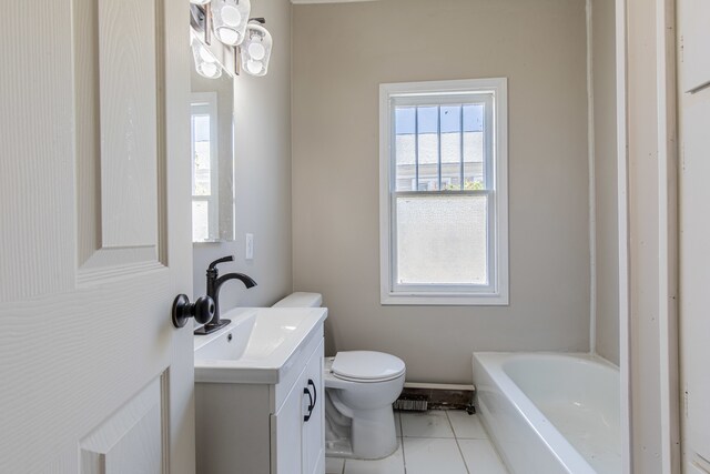 bathroom featuring toilet, vanity, tile patterned flooring, and a bathtub