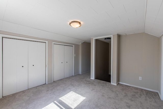 111 E 3rd St, Prophetstown, IL 61277 - unfurnished bedroom featuring carpet flooring, multiple closets, and vaulted ceiling