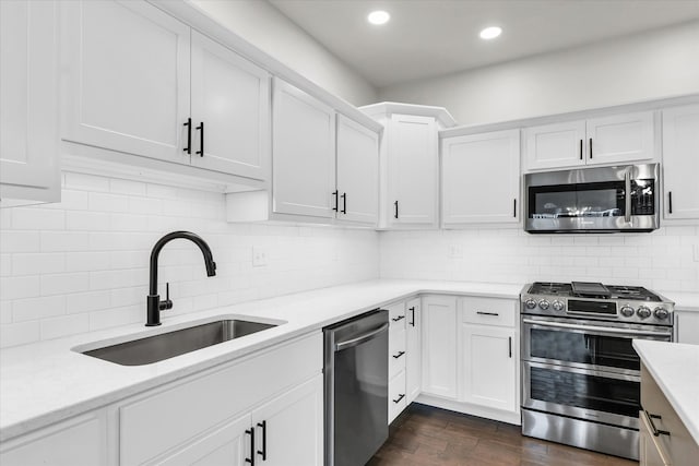 kitchen with dark hardwood / wood-style flooring, white cabinetry, sink, and appliances with stainless steel finishes