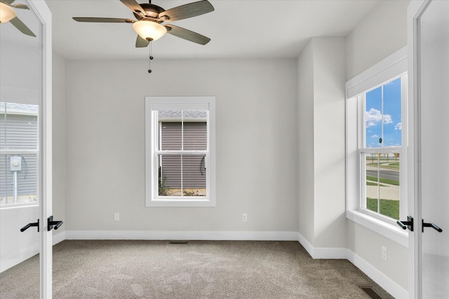 spare room featuring a wealth of natural light, carpet, and ceiling fan