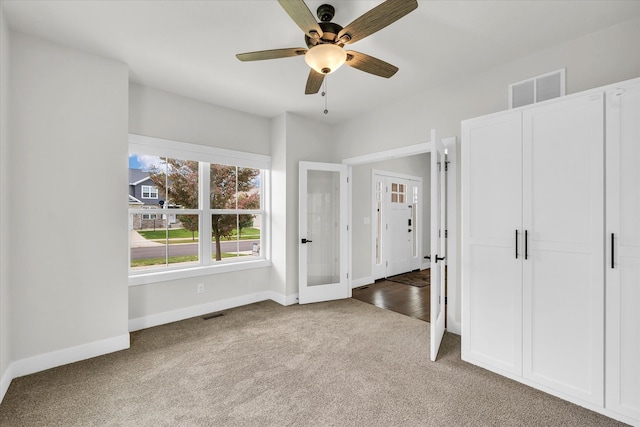 unfurnished bedroom featuring ceiling fan, french doors, and carpet