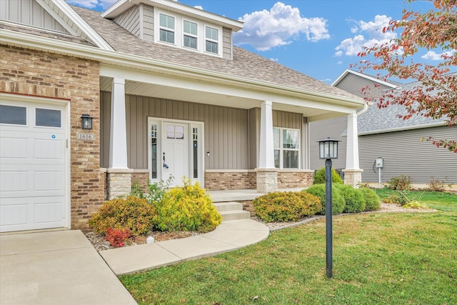 property entrance featuring a garage, a yard, and covered porch