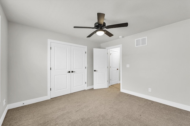 unfurnished bedroom featuring light colored carpet, ceiling fan, and a closet