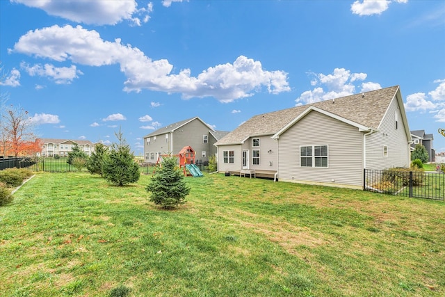 back of property with a lawn and a wooden deck