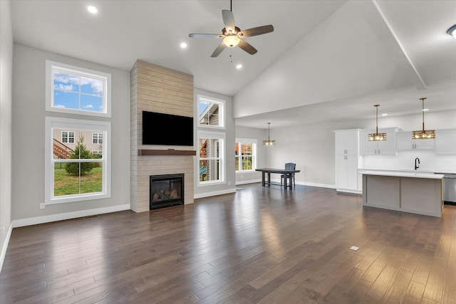 unfurnished living room featuring high vaulted ceiling and dark hardwood / wood-style floors