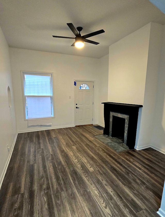 unfurnished living room featuring dark hardwood / wood-style floors and ceiling fan