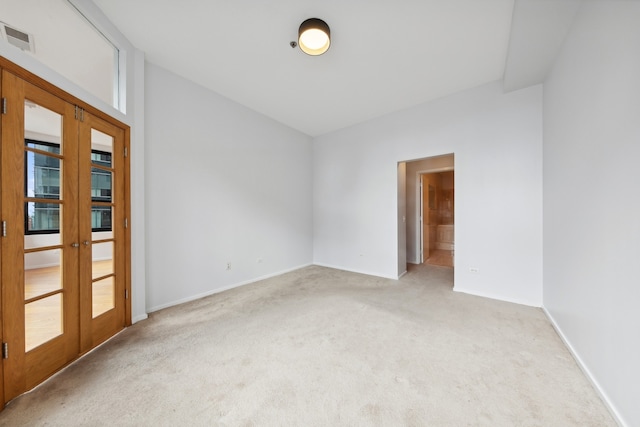 carpeted spare room with french doors