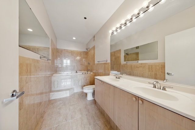 bathroom featuring tile walls, vanity, tile patterned floors, and toilet