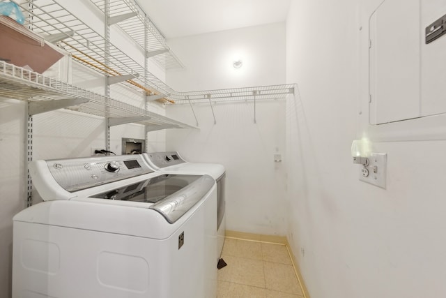 clothes washing area with washing machine and clothes dryer and electric panel