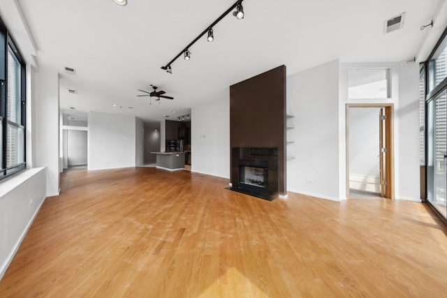 unfurnished living room featuring a wealth of natural light and light hardwood / wood-style floors