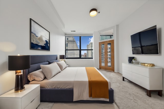 bedroom with floor to ceiling windows and light colored carpet