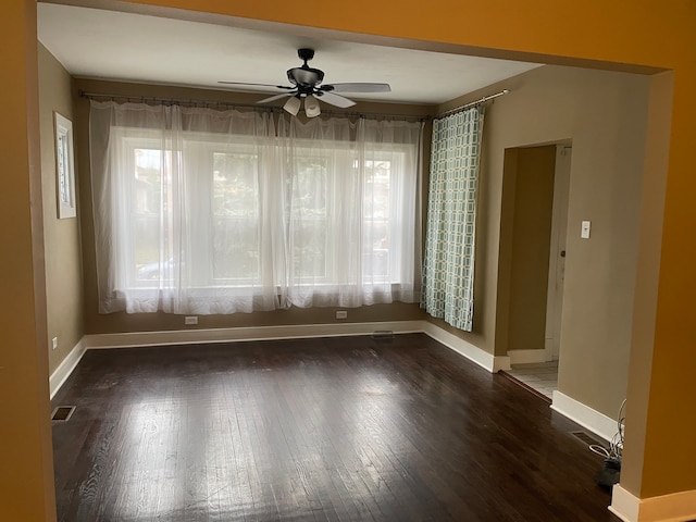 empty room with ceiling fan and dark hardwood / wood-style floors