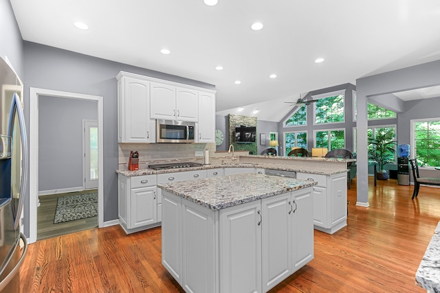 kitchen featuring white cabinets, kitchen peninsula, and a center island