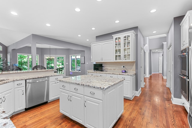 kitchen with dishwasher, a center island, light hardwood / wood-style floors, and white cabinets