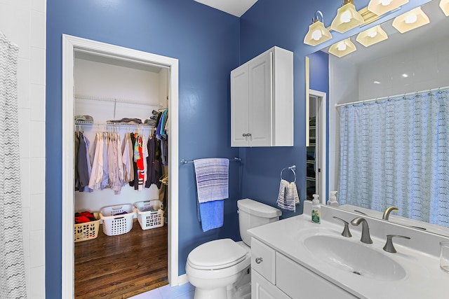 bathroom with hardwood / wood-style floors, vanity, and toilet