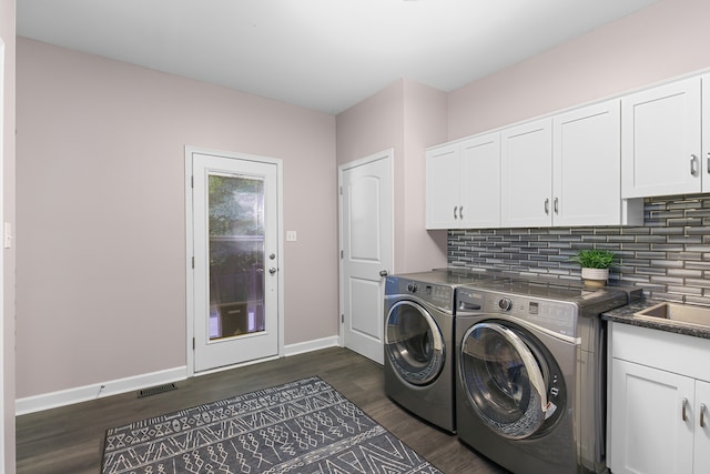 washroom featuring dark hardwood / wood-style flooring, cabinets, and independent washer and dryer