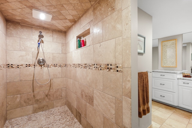 bathroom featuring tiled shower and vanity