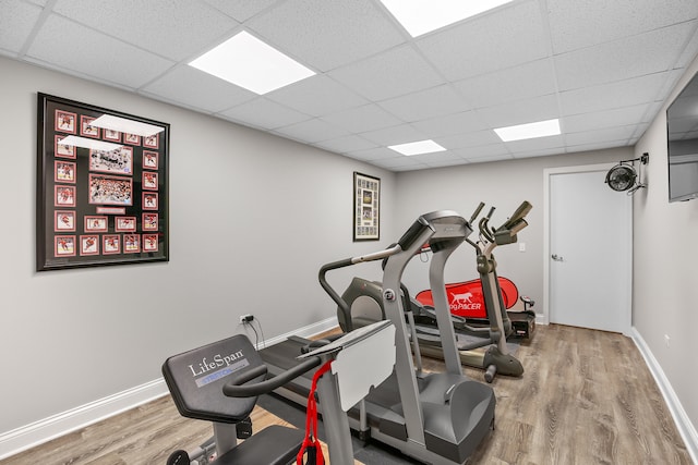 workout area featuring a paneled ceiling and wood-type flooring