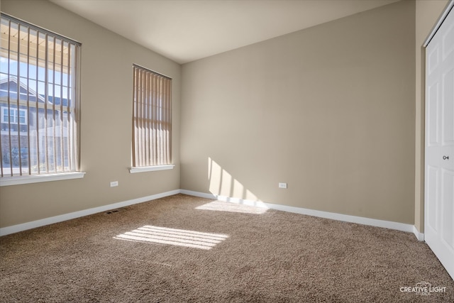 unfurnished bedroom featuring carpet, multiple windows, and a closet