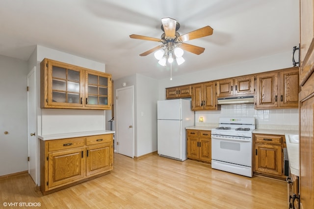 kitchen with white appliances, ceiling fan, light wood-type flooring, and tasteful backsplash