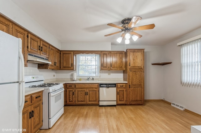 kitchen featuring white appliances, ceiling fan, sink, and light hardwood / wood-style flooring