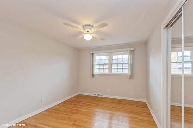 empty room with ceiling fan and light hardwood / wood-style flooring