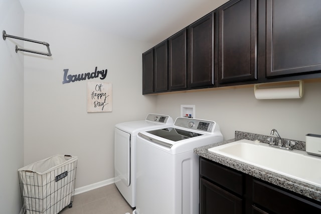 clothes washing area featuring cabinets, light tile patterned floors, sink, and washing machine and clothes dryer