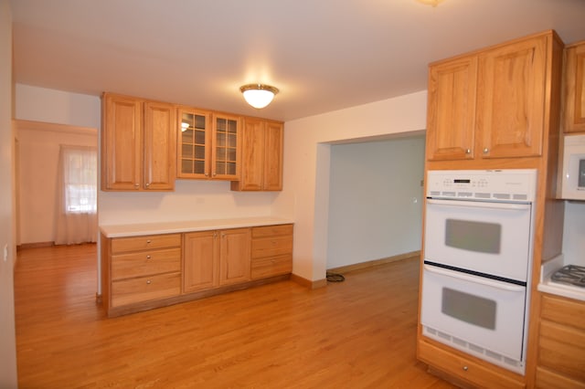 kitchen featuring light wood-type flooring and white appliances