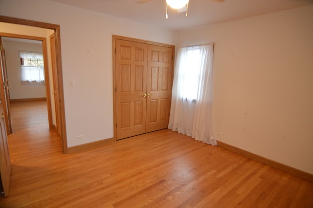 unfurnished bedroom with light hardwood / wood-style flooring, ceiling fan, and a closet