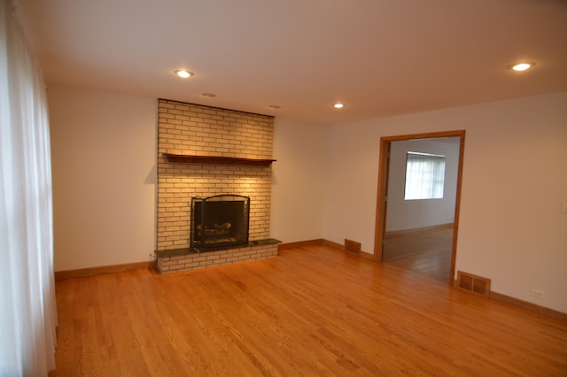 unfurnished living room featuring a fireplace and wood-type flooring