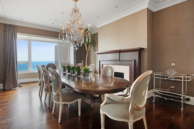 dining area with ornamental molding, hardwood / wood-style floors, a water view, and a chandelier