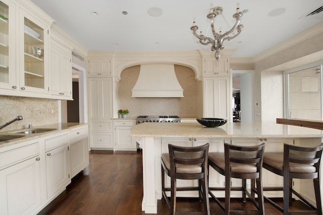 kitchen with sink, a breakfast bar, dark hardwood / wood-style floors, backsplash, and a center island