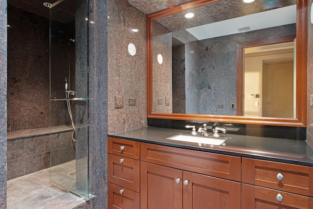 bathroom featuring vanity and a shower with door