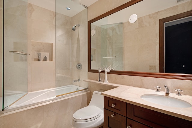 full bathroom featuring tiled shower / bath, toilet, and vanity