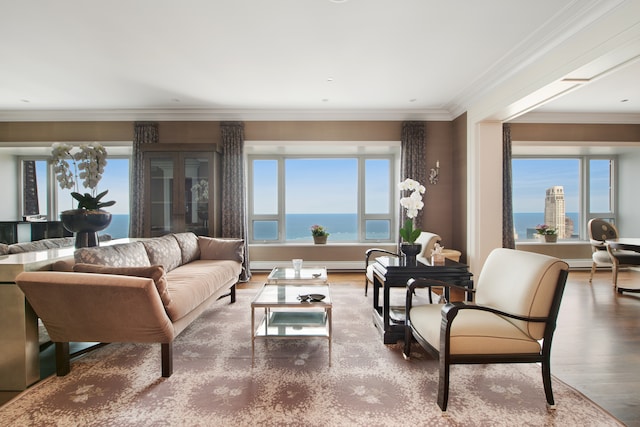 living room featuring a healthy amount of sunlight, ornamental molding, a water view, and hardwood / wood-style flooring