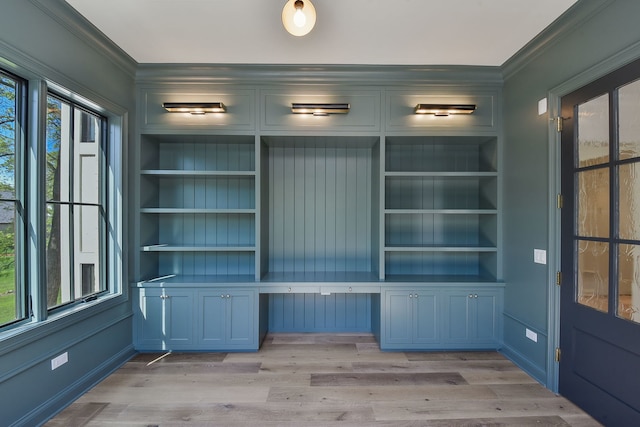 interior space featuring built in features, light hardwood / wood-style flooring, and ornamental molding