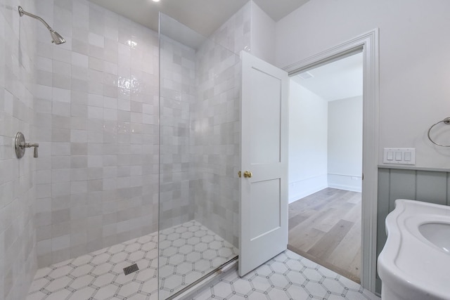 bathroom with hardwood / wood-style floors and tiled shower