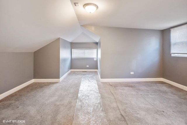 bonus room with light carpet and lofted ceiling