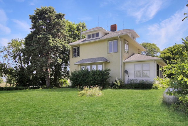 rear view of property featuring a lawn