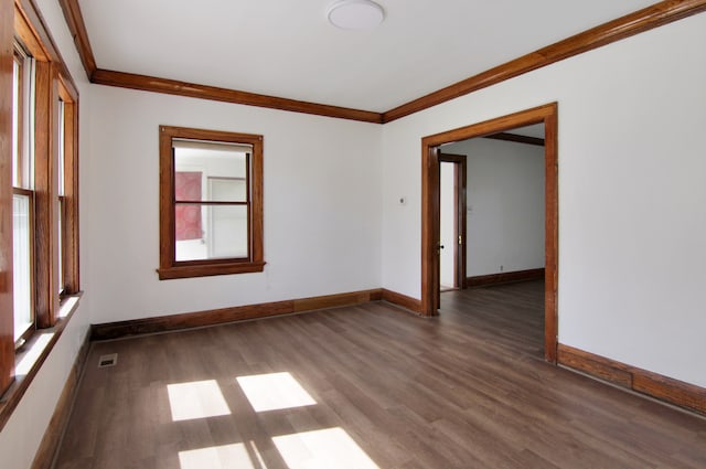 empty room with dark hardwood / wood-style floors and ornamental molding