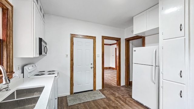 kitchen with white cabinets, white appliances, dark hardwood / wood-style floors, and sink