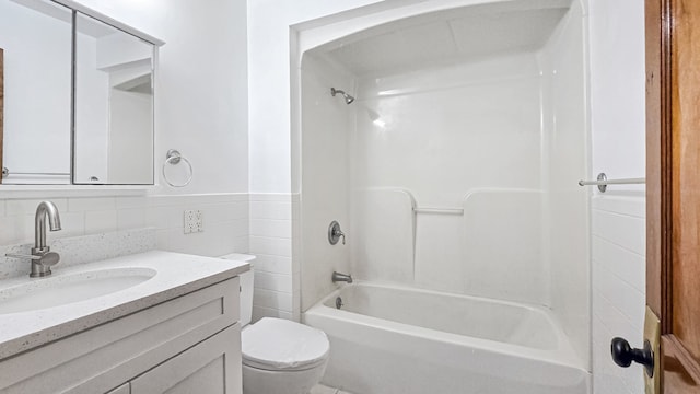 full bathroom featuring tile walls, toilet, vanity, and shower / bathing tub combination