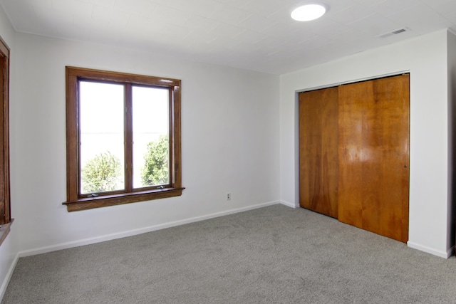 unfurnished bedroom with carpet flooring and a closet