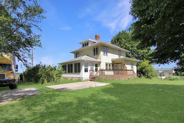 rear view of property with a patio and a lawn