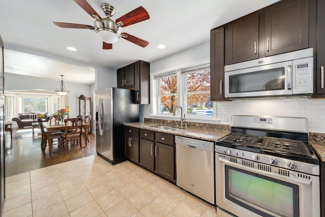 kitchen with appliances with stainless steel finishes, dark brown cabinetry, ceiling fan, sink, and light hardwood / wood-style floors