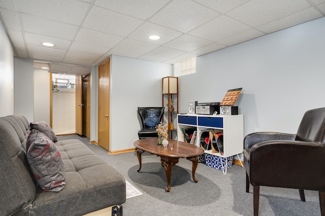 living room featuring carpet and a drop ceiling