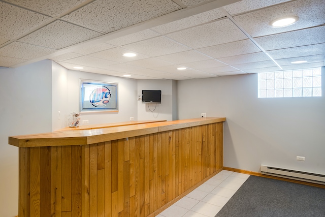 bar with a drop ceiling, light tile patterned floors, and a baseboard heating unit